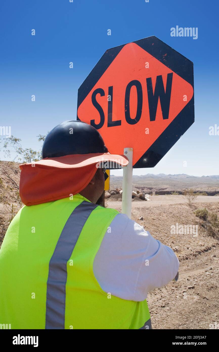 Rear view of a man standing with a road sign Stock Photo