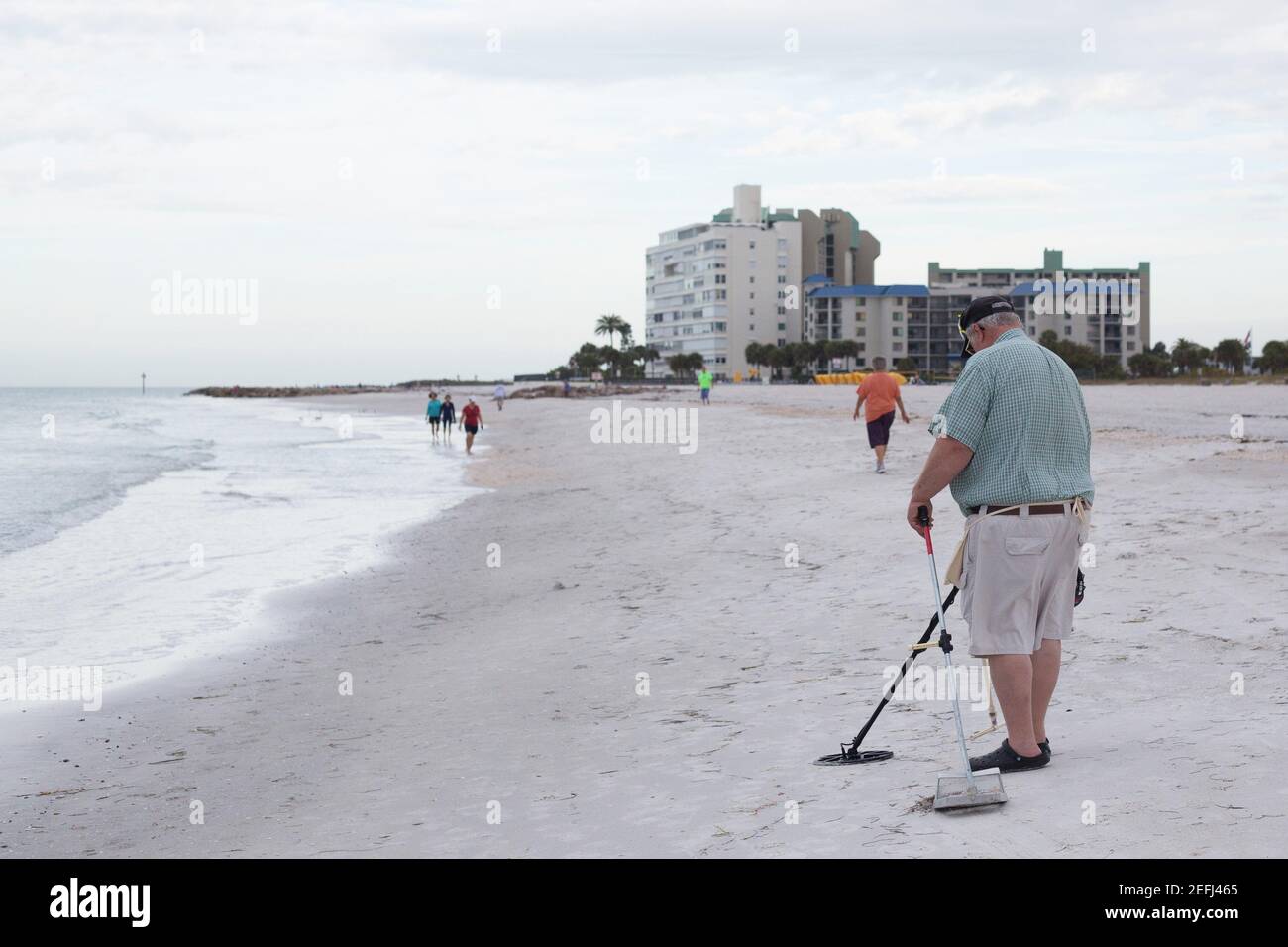 A metal detectorist on a beach in St. Petersburg, Florida Stock Photo