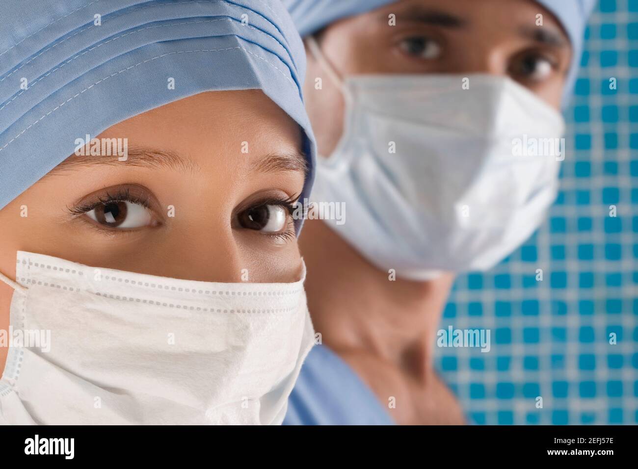 Close up of a female doctor and a male doctor wearing surgical masks ...