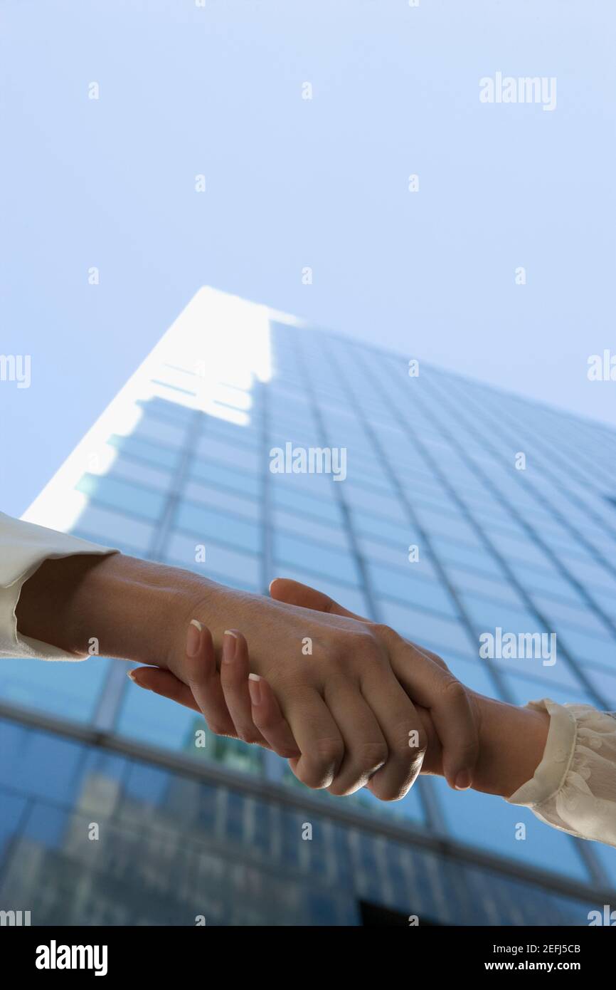 Low angle view of two people shaking hands Stock Photo