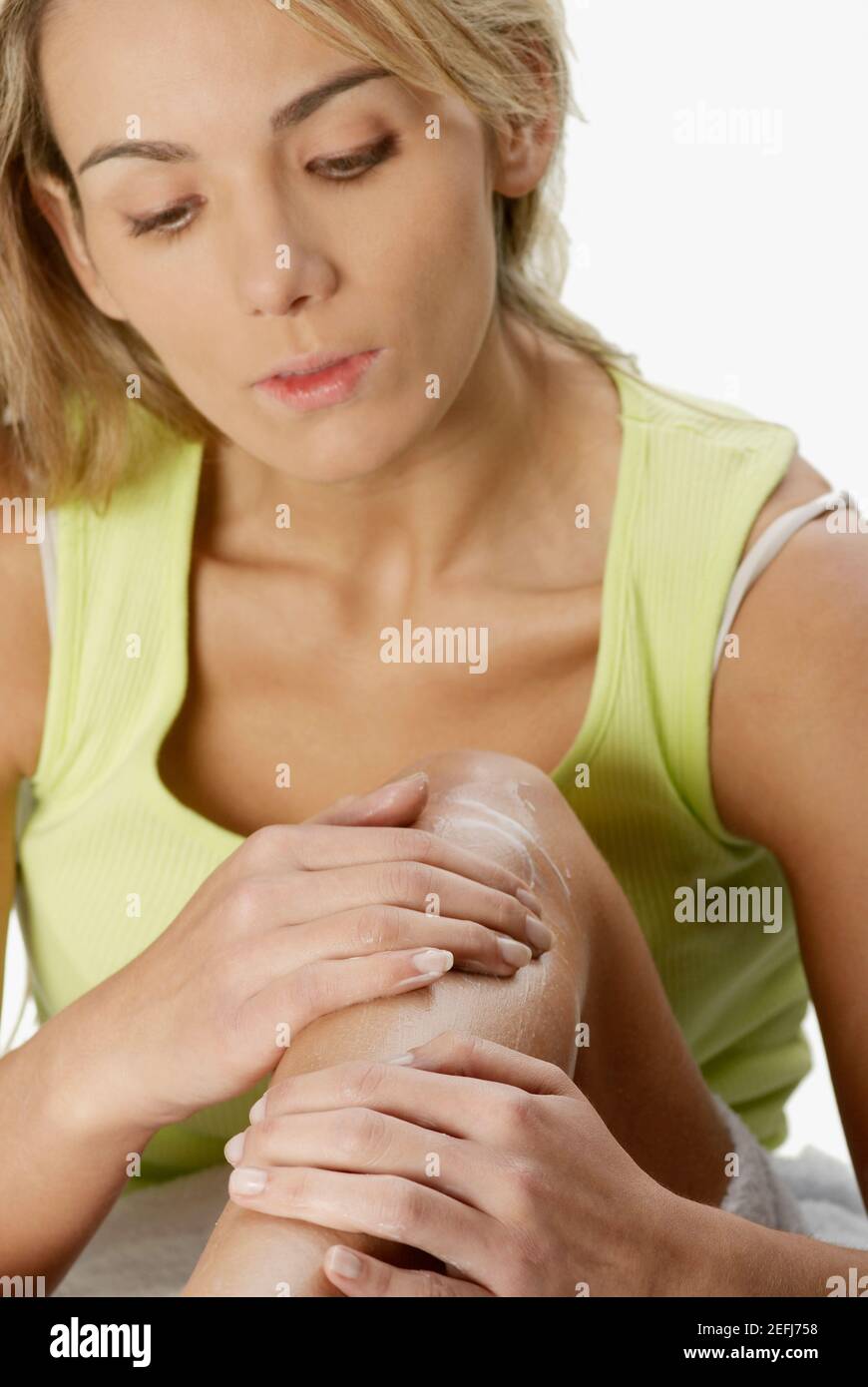 Close-up of a young woman applying hair removing cream on her leg Stock Photo