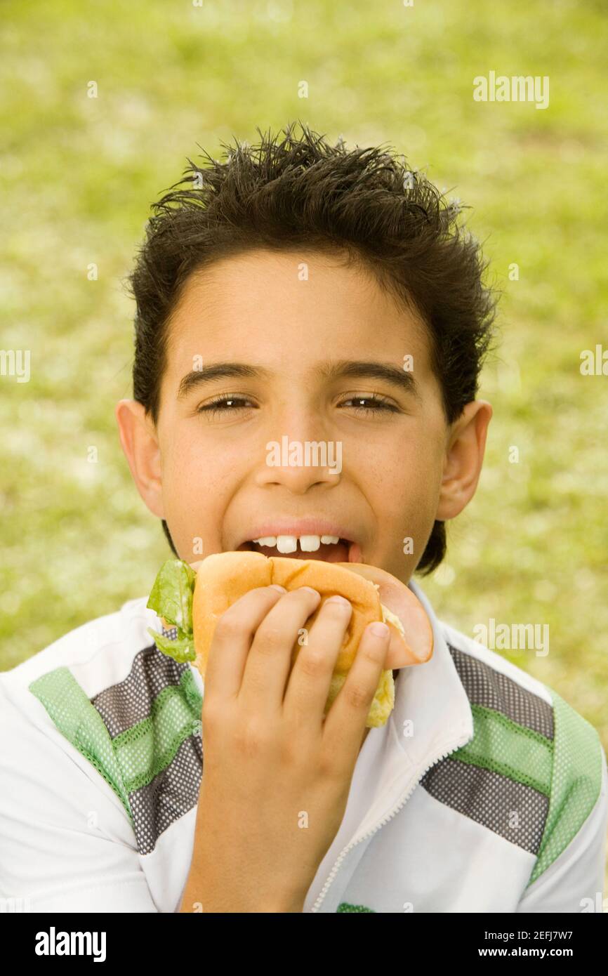 Close-up of a boy eating a burger Stock Photo