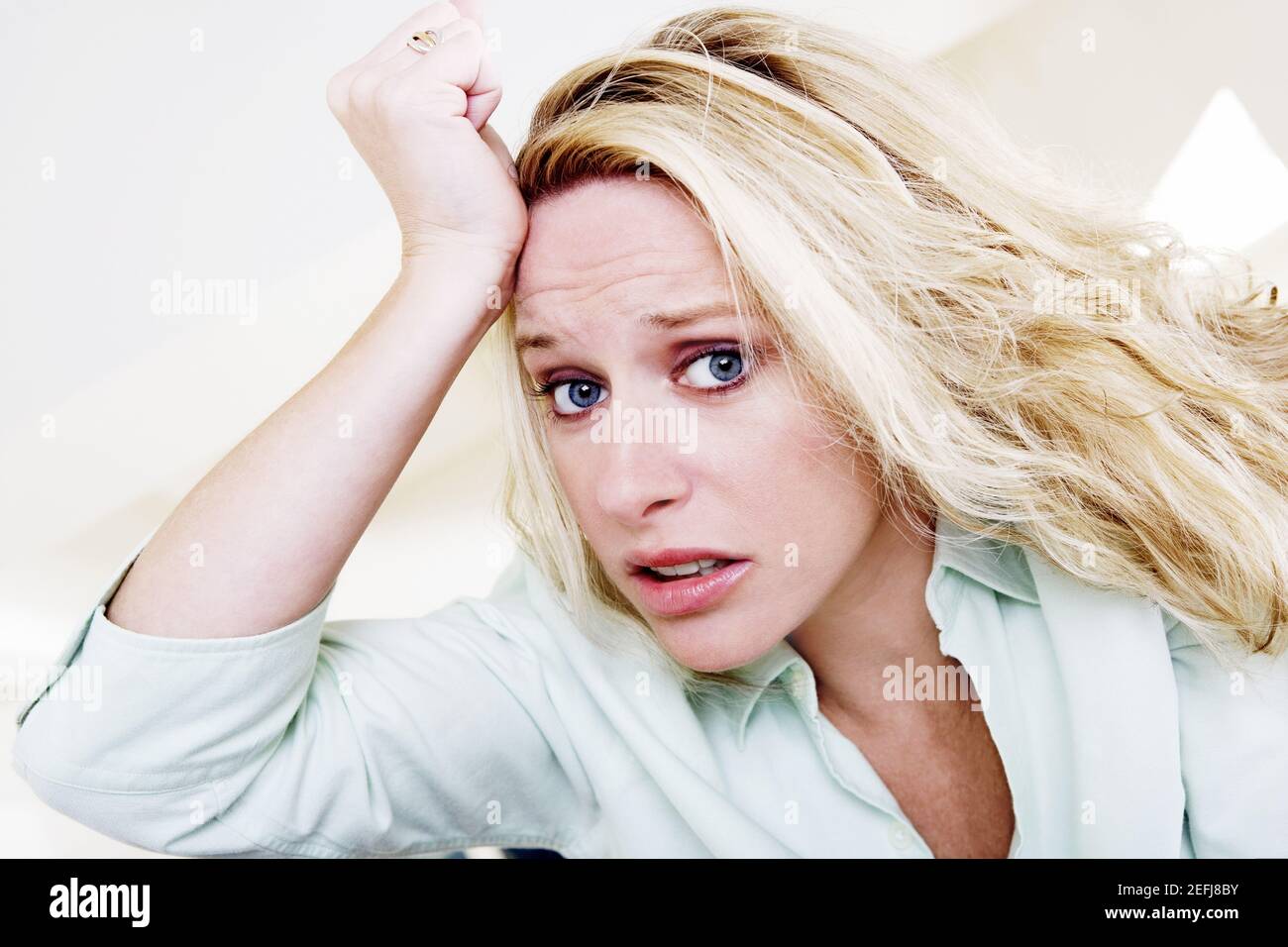 Young woman with her hand on her head Stock Photo Alamy