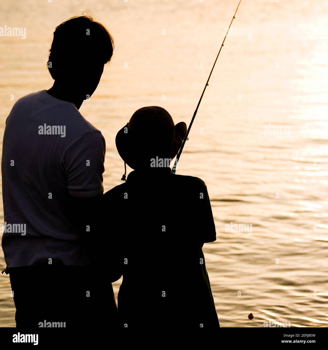Silhouette of a father and his son fishing Stock Photo - Alamy