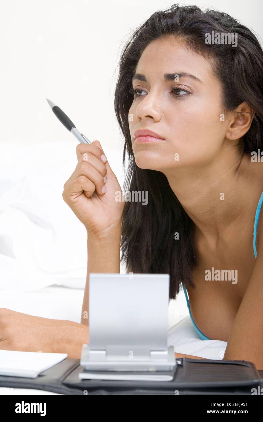 Young woman lying on a bed in front of a personal organizer Stock Photo