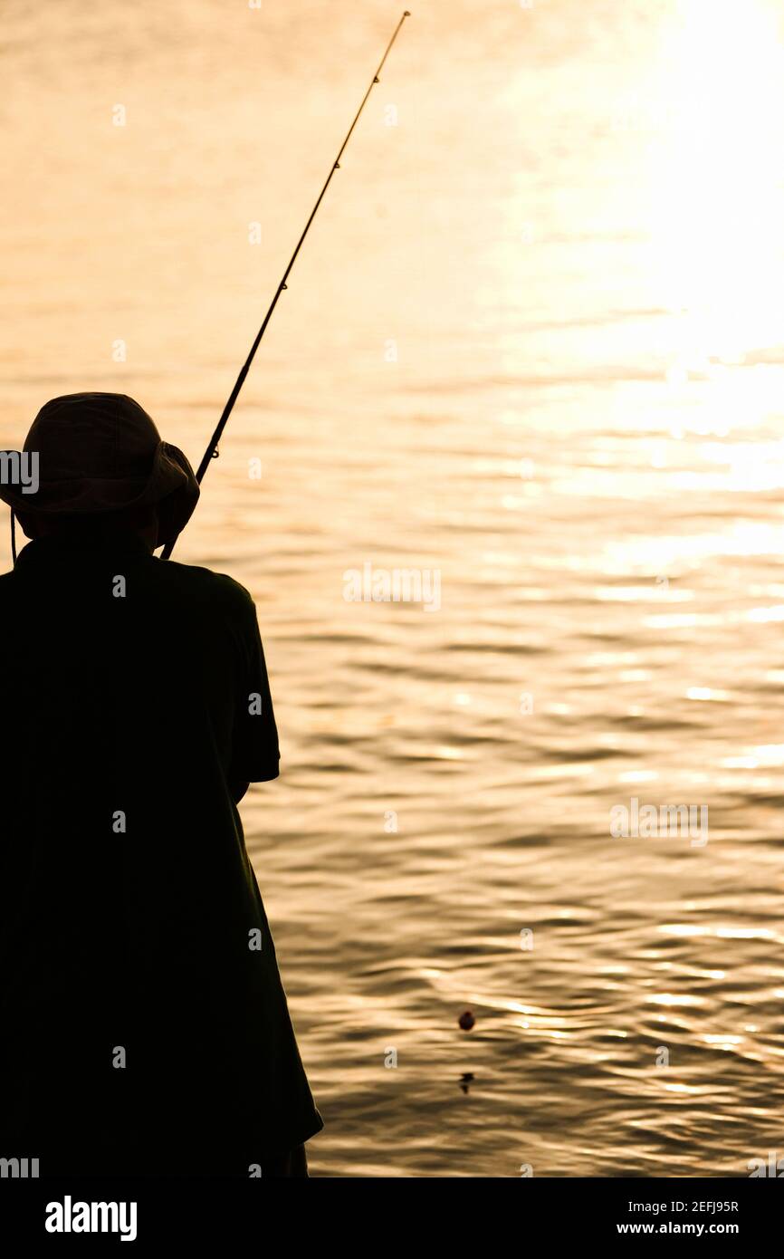 Silhouette of a father and his son fishing Stock Photo - Alamy