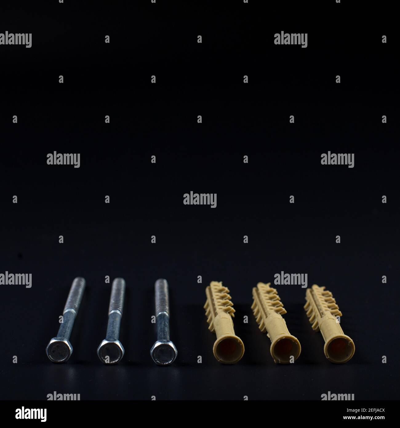 Plastic dowels close up on black background with copy space. Stock Photo