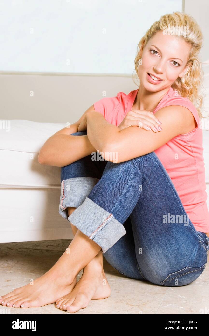 Portrait of a young woman sitting on the floor Stock Photo - Alamy