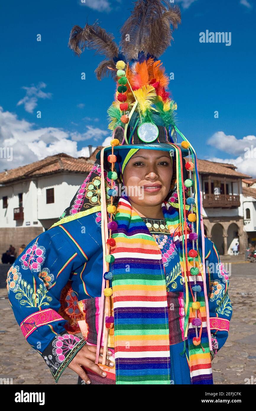 Portrait of a young woman wearing a traditional clothing and standing with arms akimbo, Peru Stock Photo