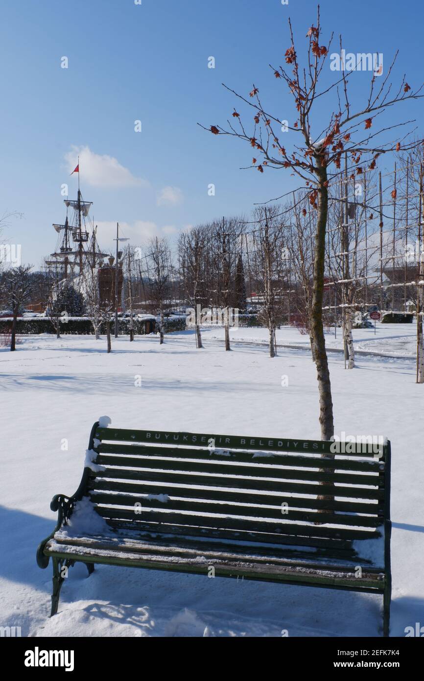 Bench at Snowy Day and Ship at the Background Stock Photo