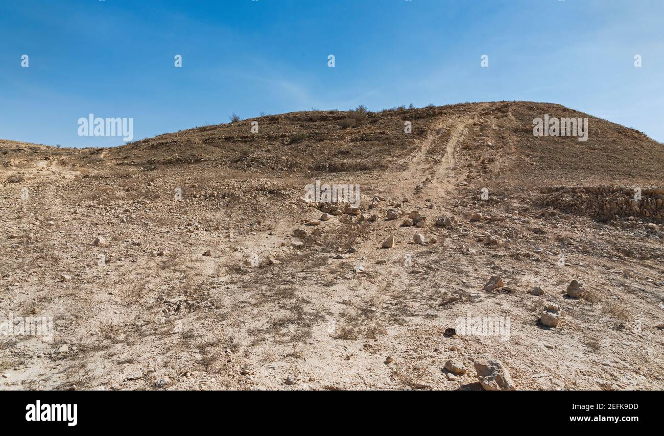 illegal off road track causing permanent damage in a protected nature reserve near the Makhtesh Ramon crater in Israel with a blue sky background Stock Photo