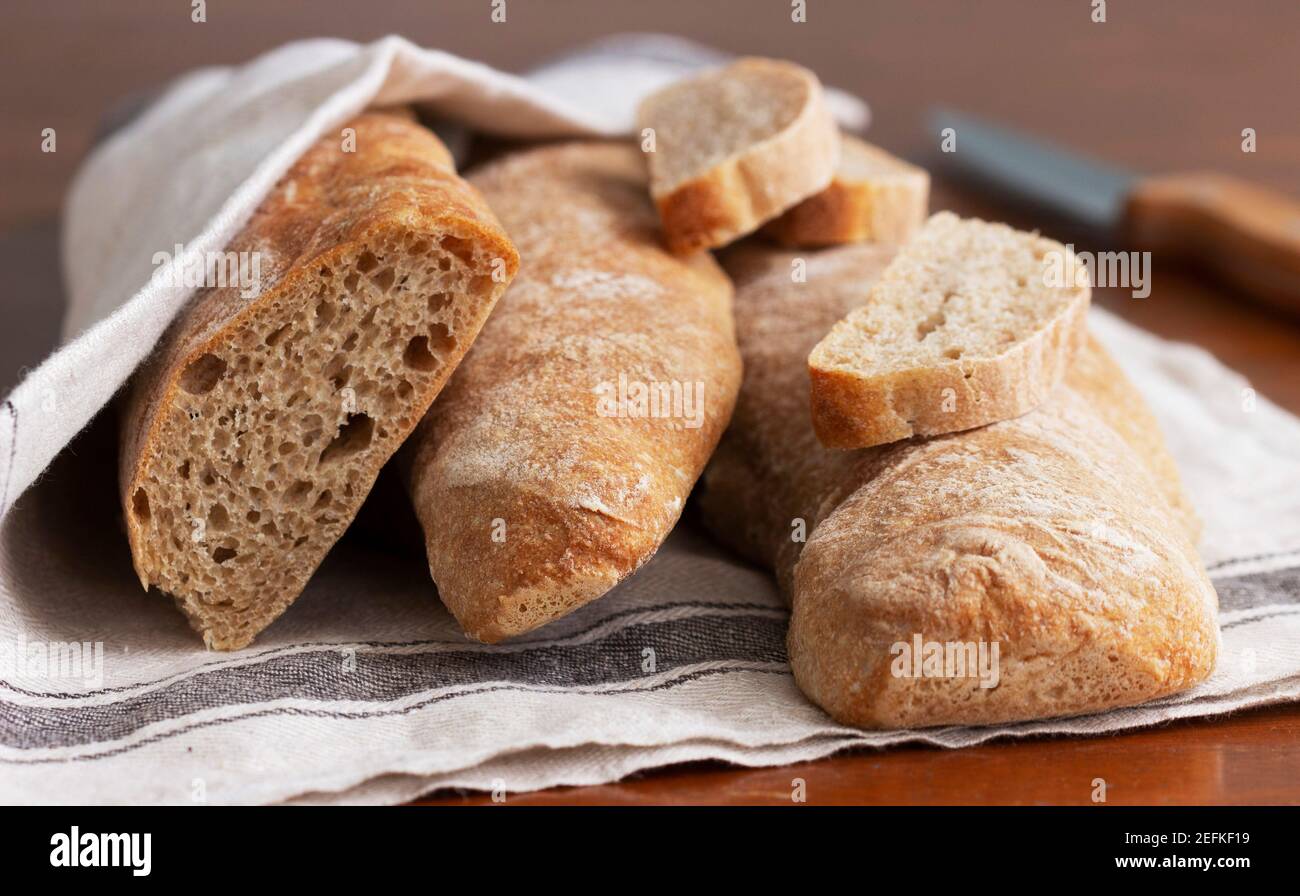 Baguette and baguette slices on a wooden table. Stock Photo