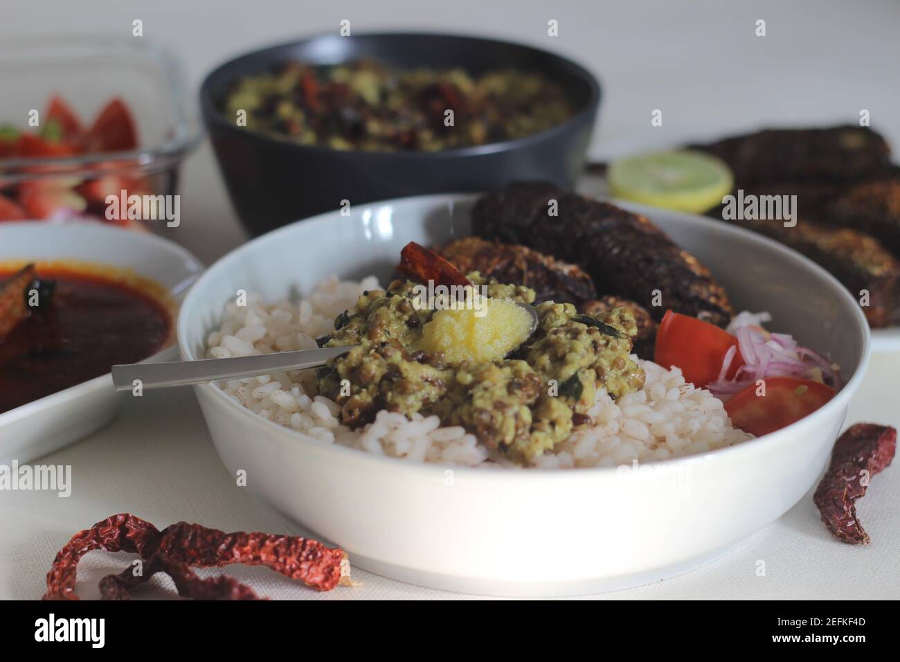 Kerala meals with red rice, sardines curry, sardine fry and coconut
