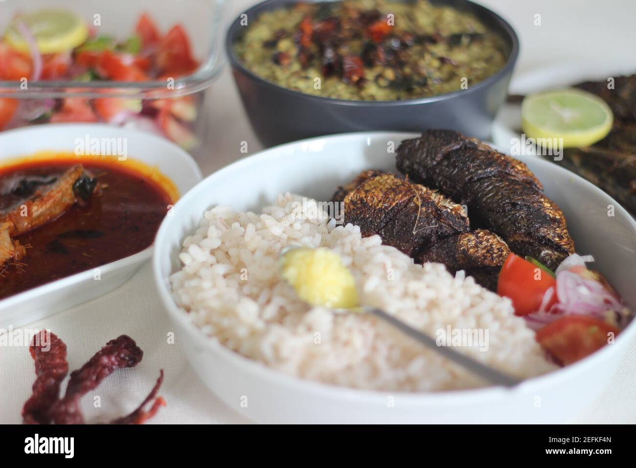 Kerala meals with red rice, sardines curry, sardine fry and coconut