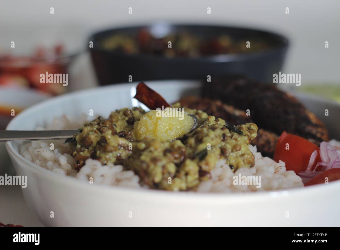 Kerala meals with red rice, sardines curry, sardine fry and coconut