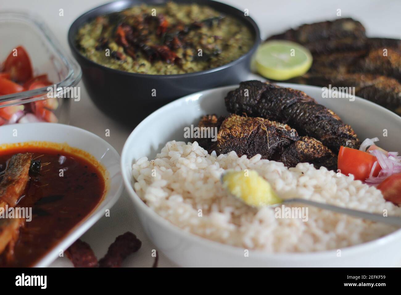 Kerala meals with red rice, sardines curry, sardine fry and coconut