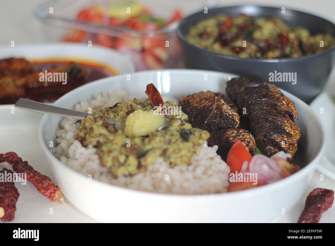 Kerala meals with red rice, sardines curry, sardine fry and coconut
