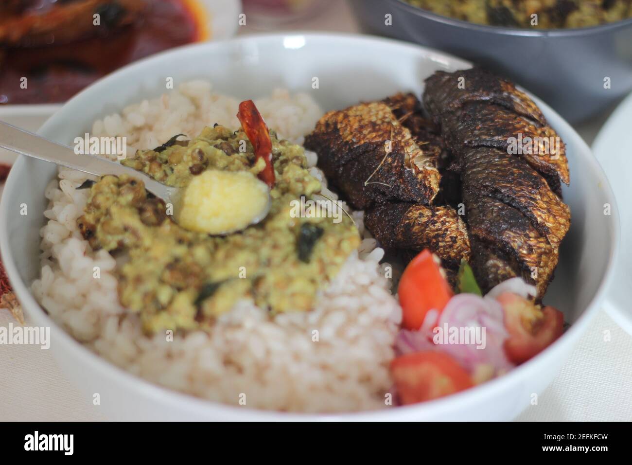 Kerala meals with red rice, sardines curry, sardine fry and coconut