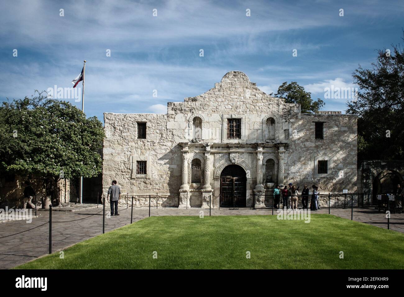 10-18-2012 San Antonio USA - Front of historical Alamo with tourists standing outside under a blue sky with whispy clouds Stock Photo