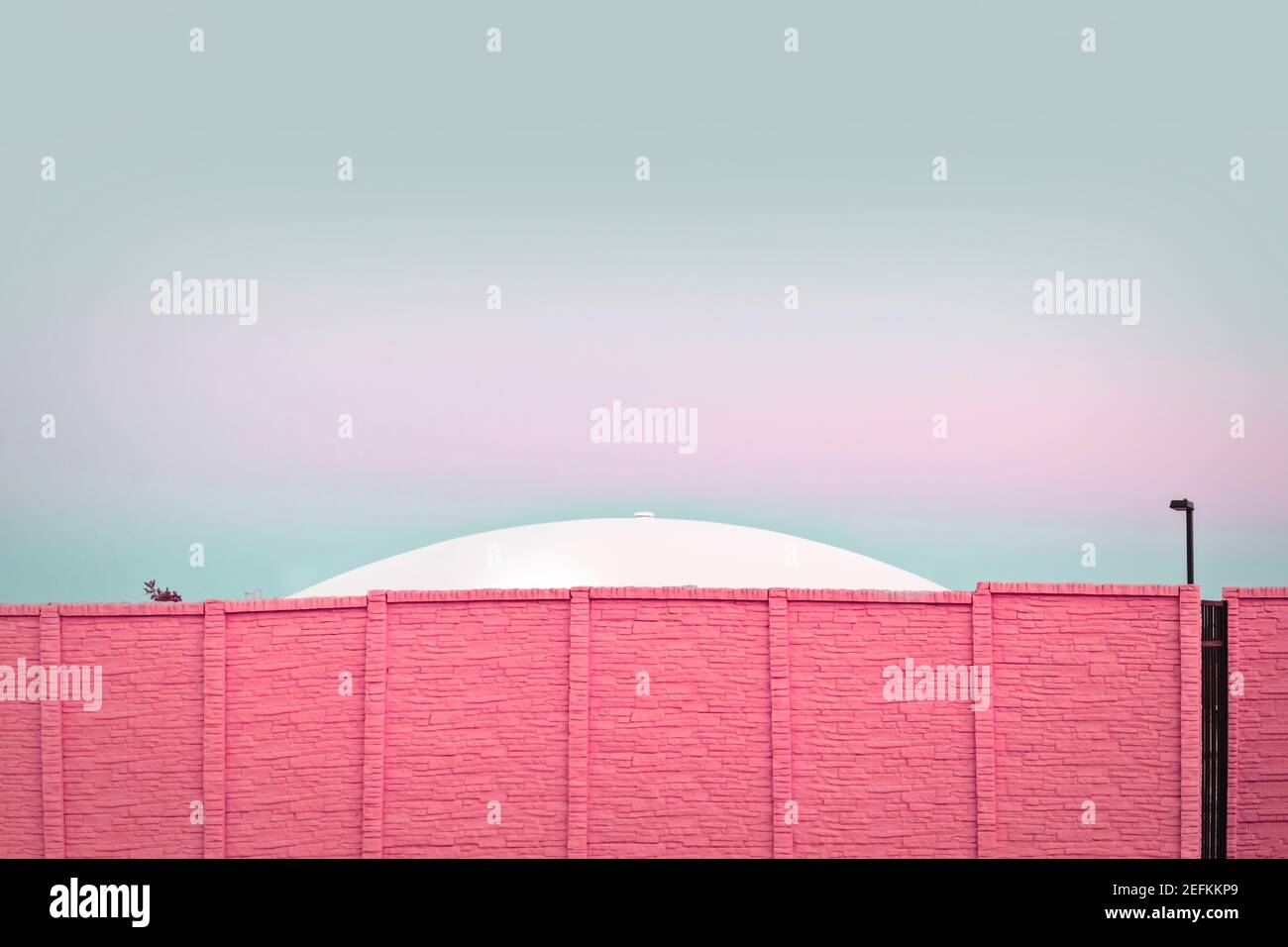 Modern architecture, UFO behind a pink brick wall Stock Photo