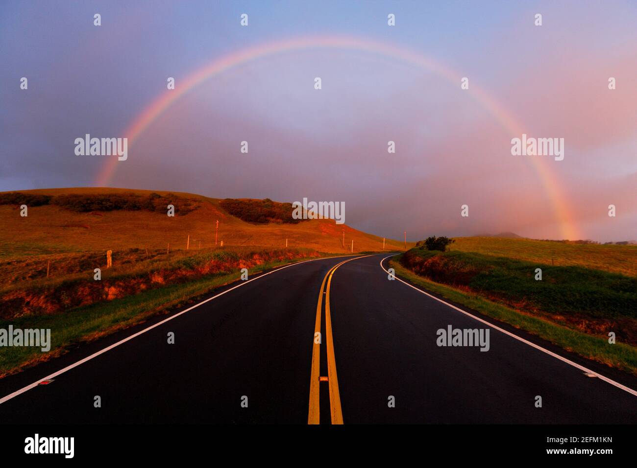 Double Rainbow appears over the high plateau road at sunset Hawaii USA. Stock Photo
