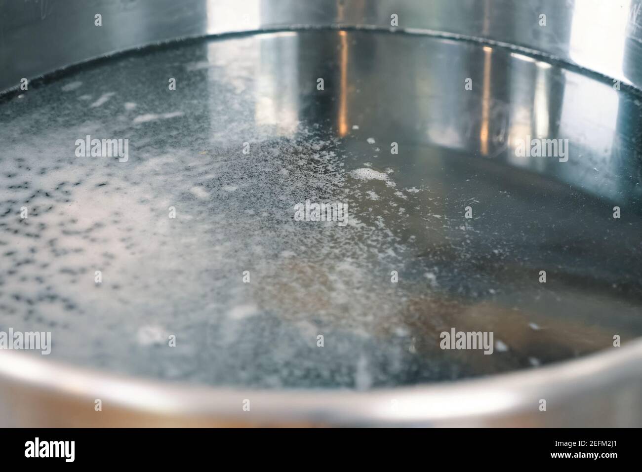 Foam on the surface of the water in a pan. Boiling water Stock Photo