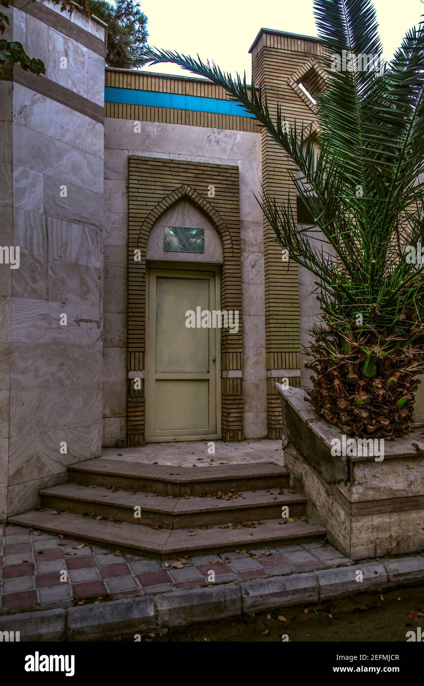 An old building of the premises of the cultural center with an entrance door lined with white brick in the eastern style in the city of Tehran on Razi Stock Photo