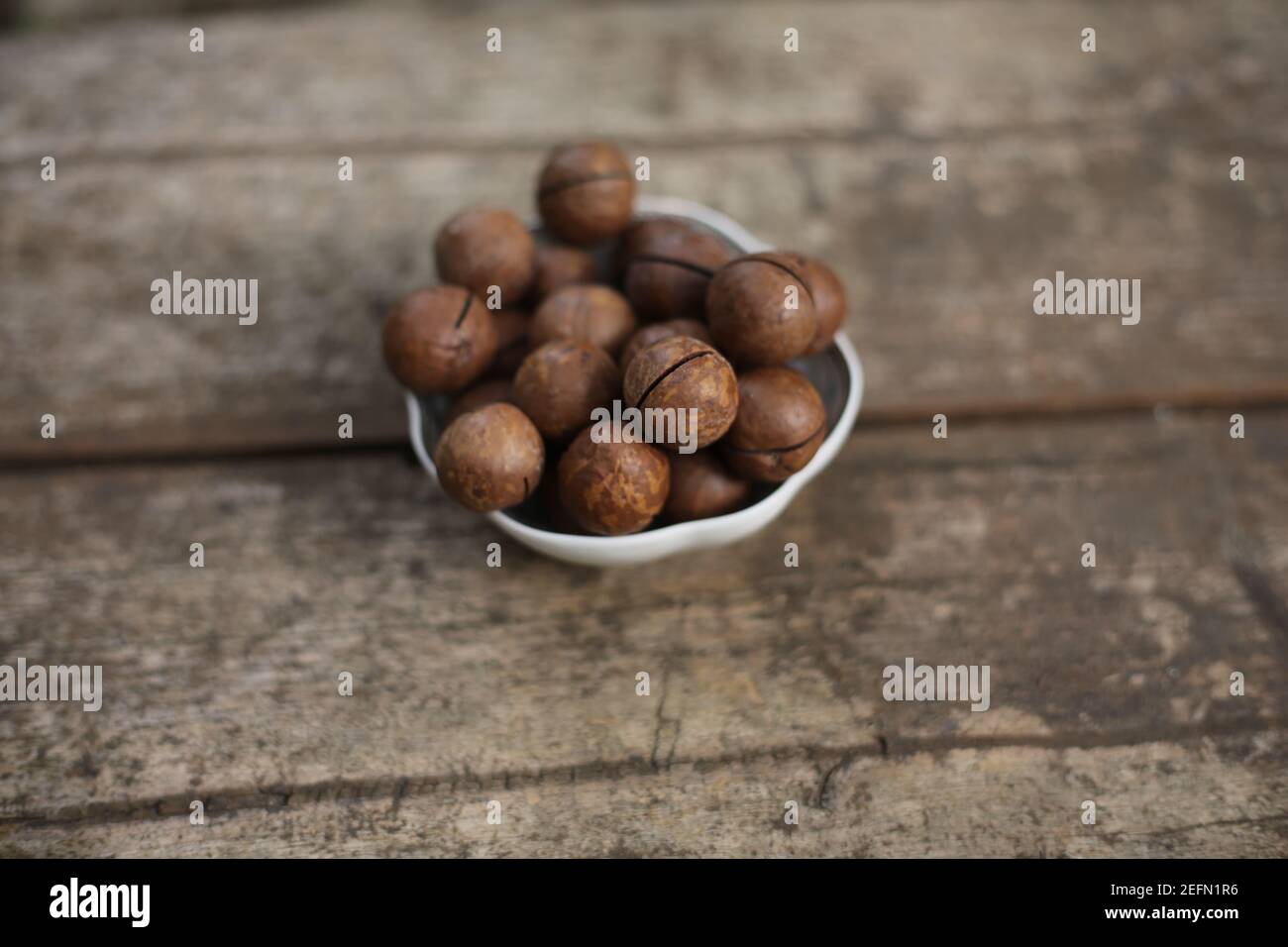 macadamia nuts isolated on a wooden background with copy space Stock Photo