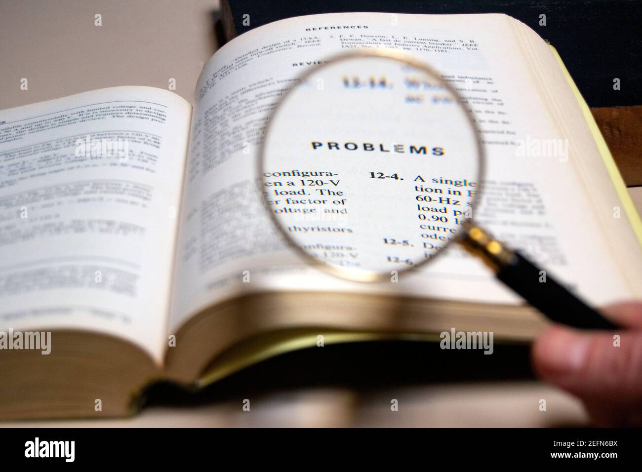 magnifying glass analysing the word'pronlems' on a technical test book Stock Photo