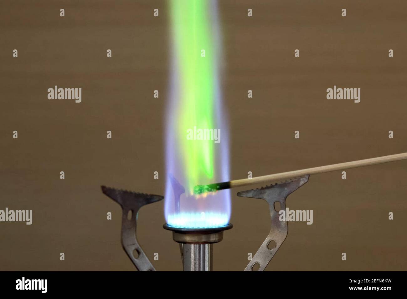 Ignition of copper oxide on a mini burner with a wooden stick. on the