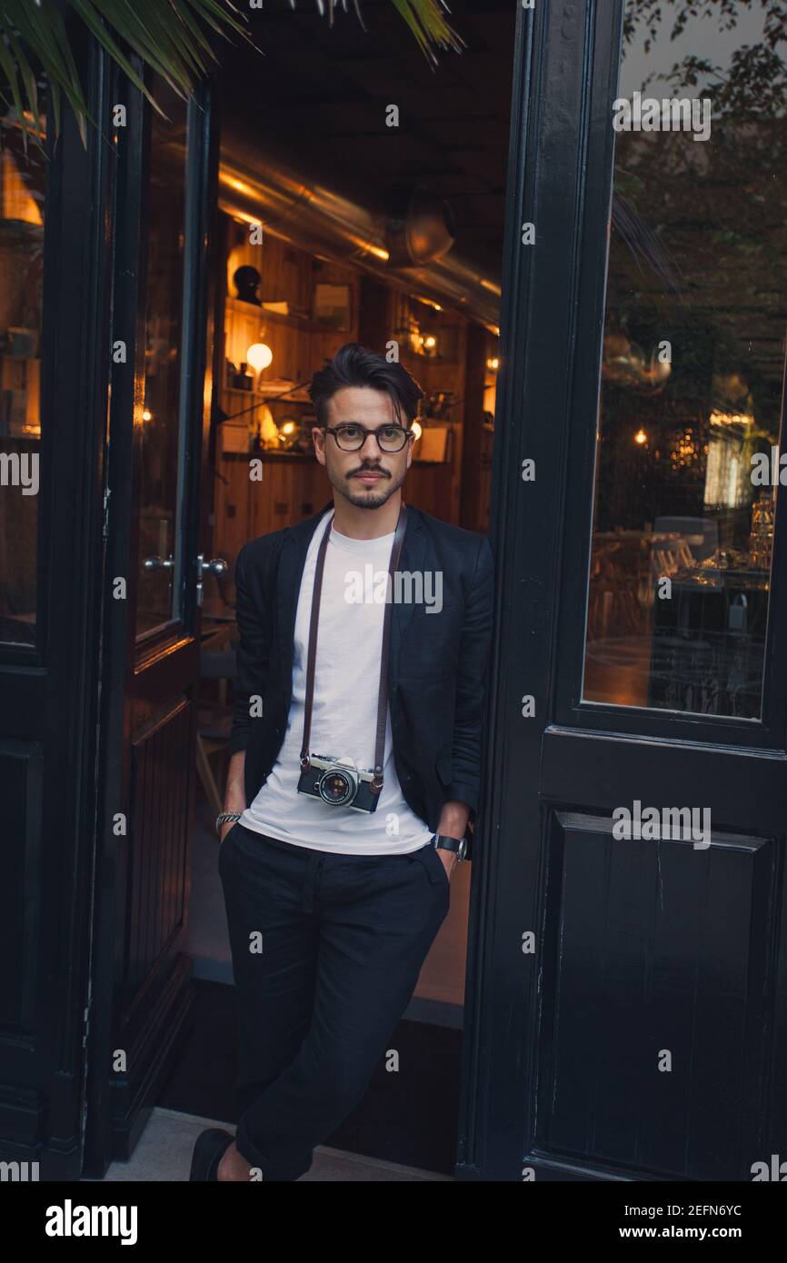 Young man with vintage camera leaving design Hotel Tipografia Do Conto in Porto Portugal Stock Photo