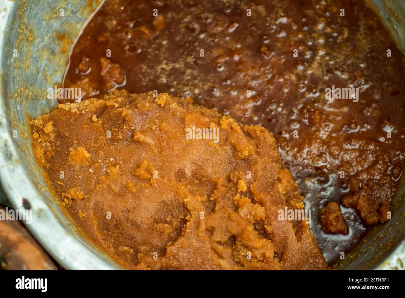 Molasses with sugarcane or stacks of raw Colombian Panela, or unrefined whole cane sugar or Sugarcane molasses Stock Photo