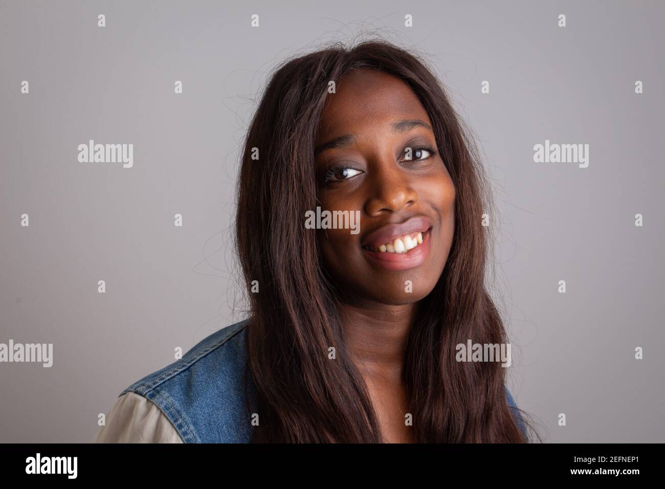 Portrait of a gorgeous attractive African girl who smiles and is very happy. Model isolated on grey background. Stock Photo
