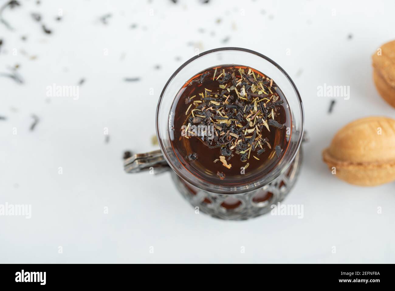 A cup of herbal tea with sweet walnut shaped cookie Stock Photo - Alamy