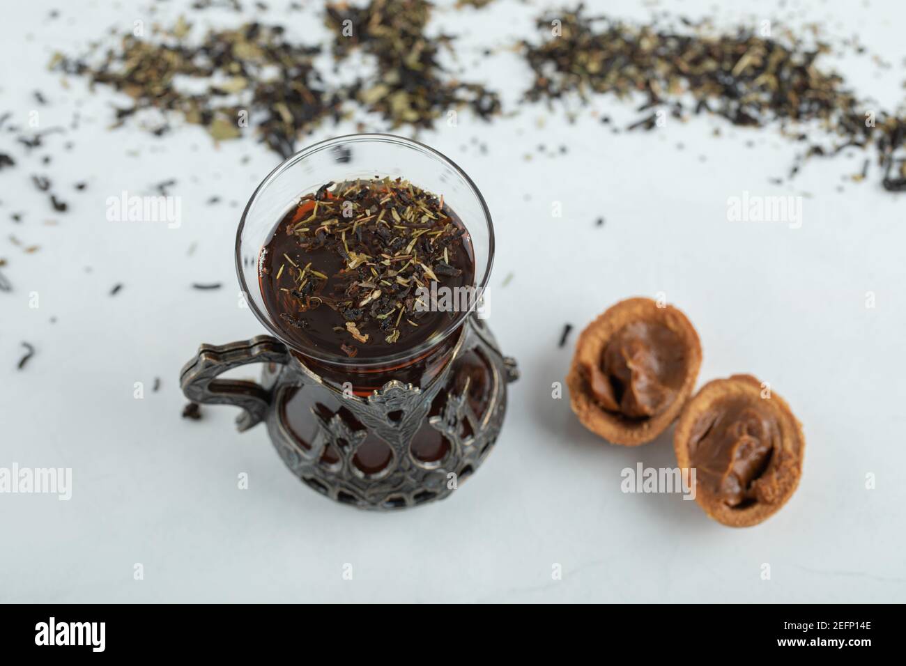 A cup of herbal tea with sweet walnut shaped cookie Stock Photo - Alamy