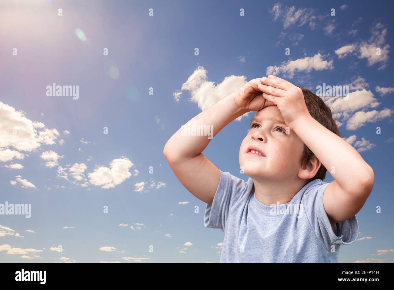 Little child boy looks up to the sky. Dream and hope concept Stock Photo