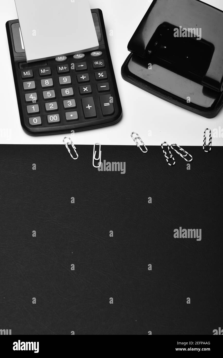 Note paper, hole punch and paper clips on white surface. Office tools