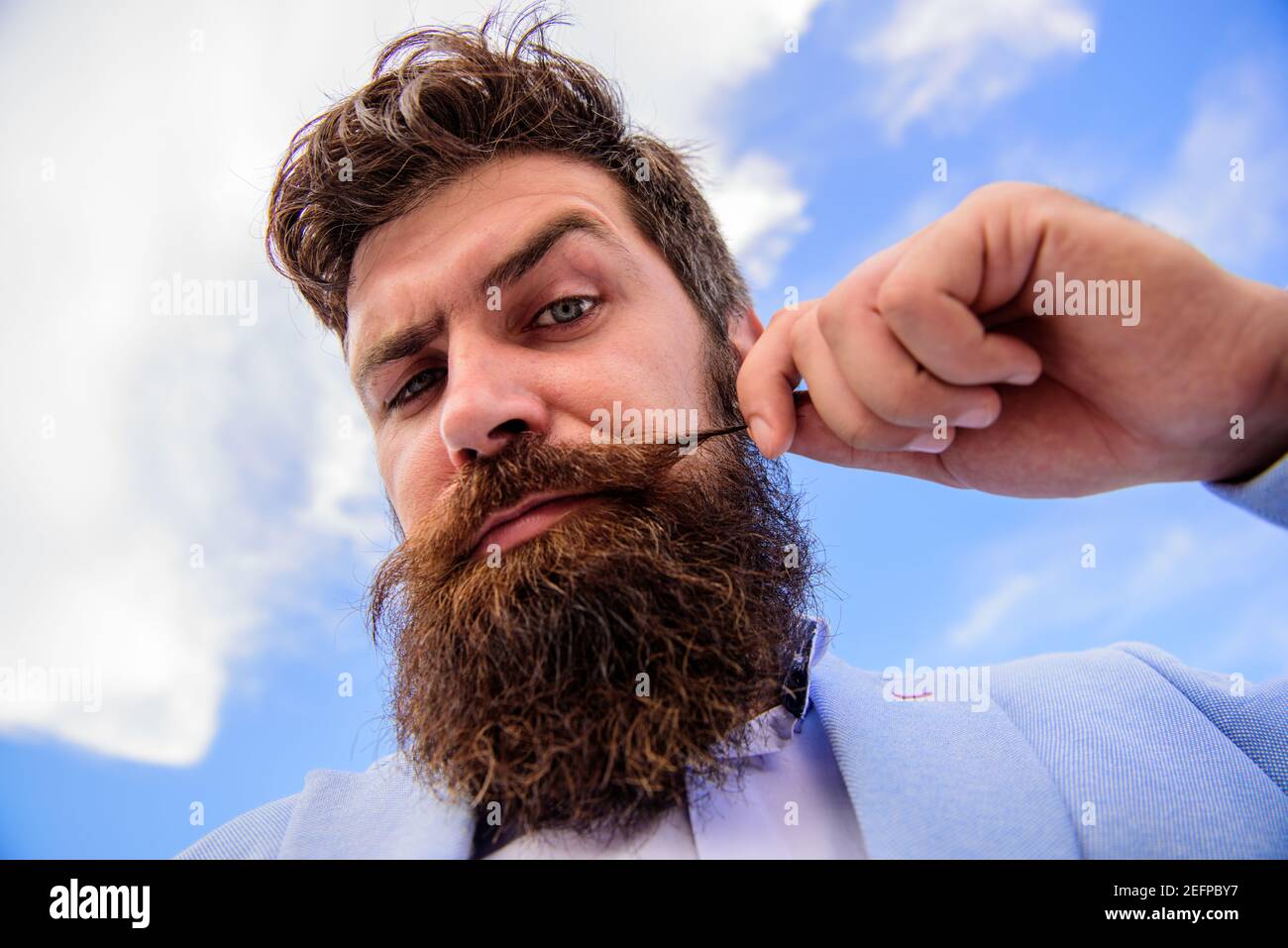 Hipster handsome bearded attractive guy close up. Man bearded hipster with mustache sky