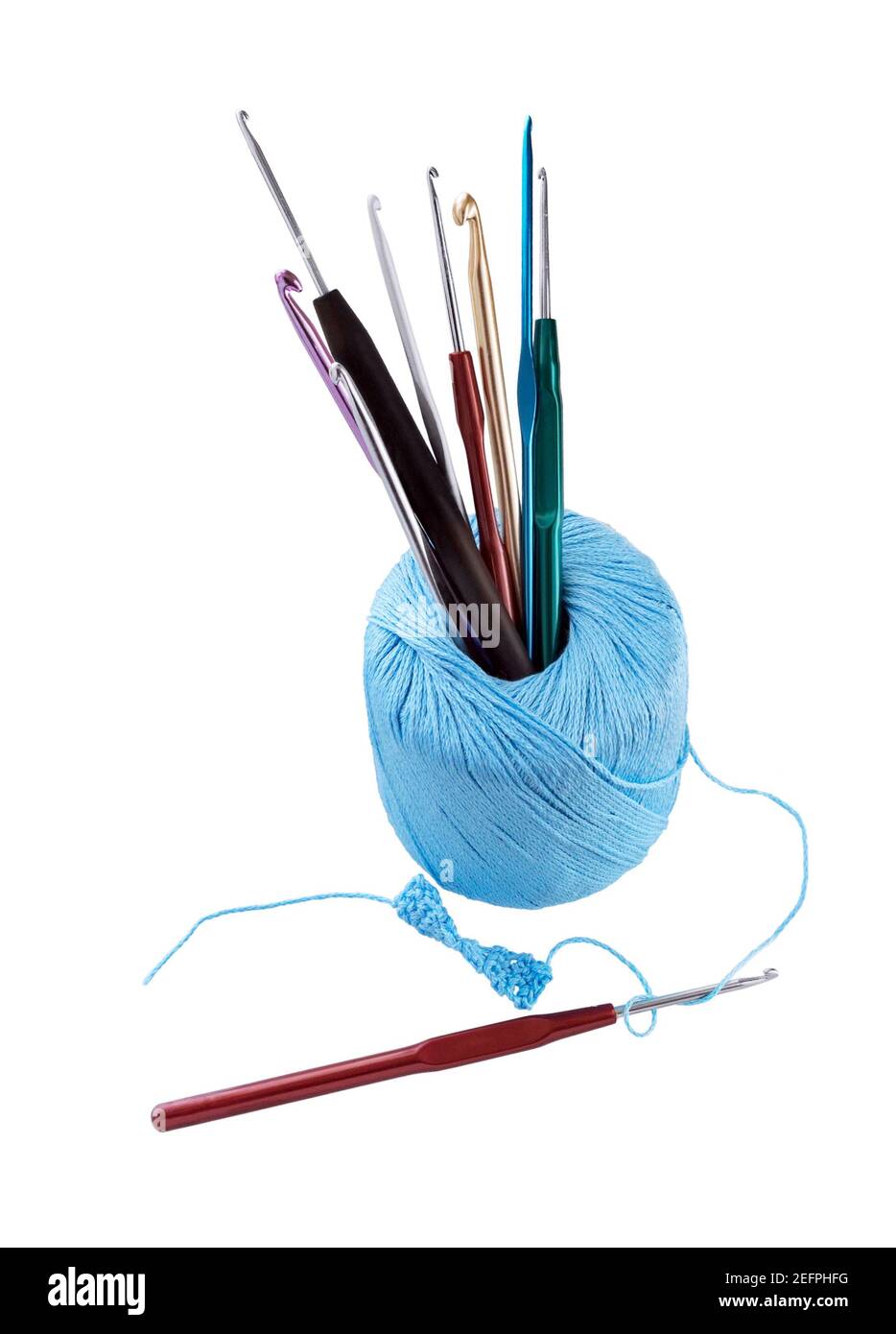 Hook crochet set. Ball of yarn with different sizes of crochet hooks isolated on white background. Stock Photo