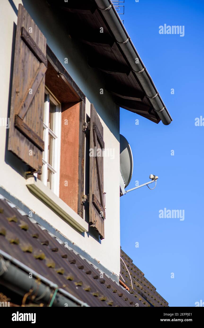 Rustic house with wooden shutters and satellite antenna Stock Photo