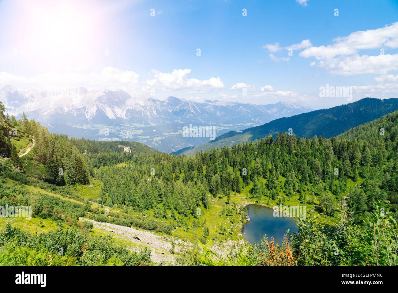 Magical idyllic landscape with lake in mountains in Alps Europe. tourist trail on green hills in Alps. Beautiful rock and admire amazing view to mountain peaks. Fantastic sunny day is in mountain lake Stock Photo