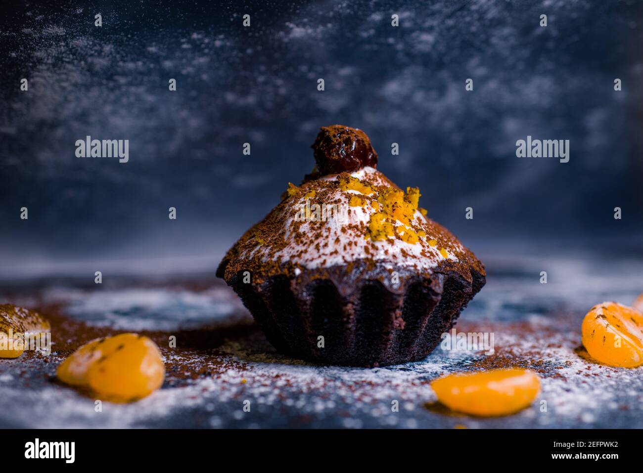chocolate muffins sprinkled with goodies with cherries and chocolate and cocoa Stock Photo