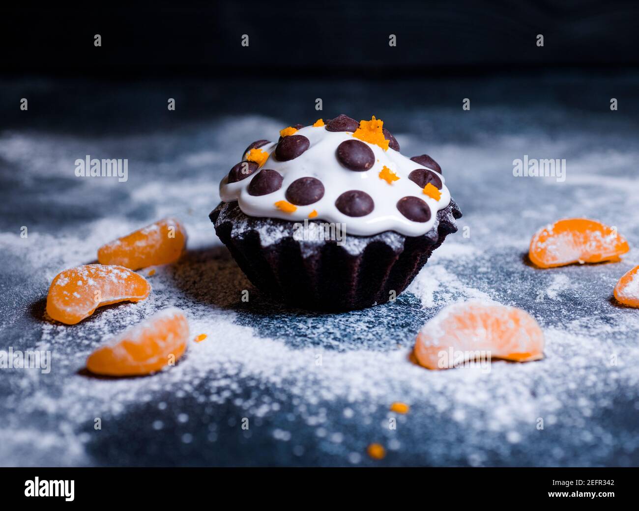 chocolate muffins sprinkled with goodies with cherries and chocolate and cocoa Stock Photo