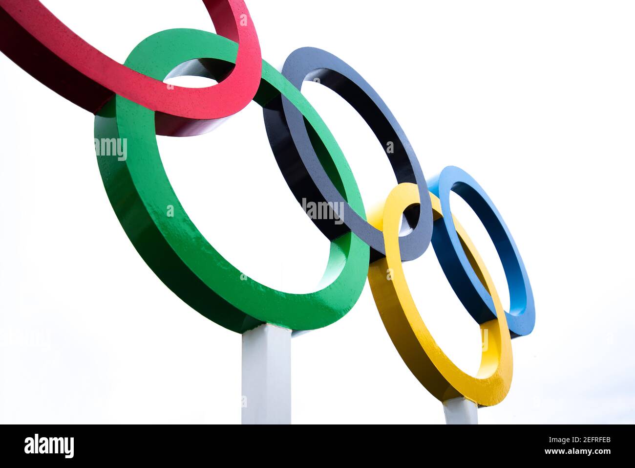 Five intertwined rings in blue, black, red, yellow and green on a white background Stock Photo