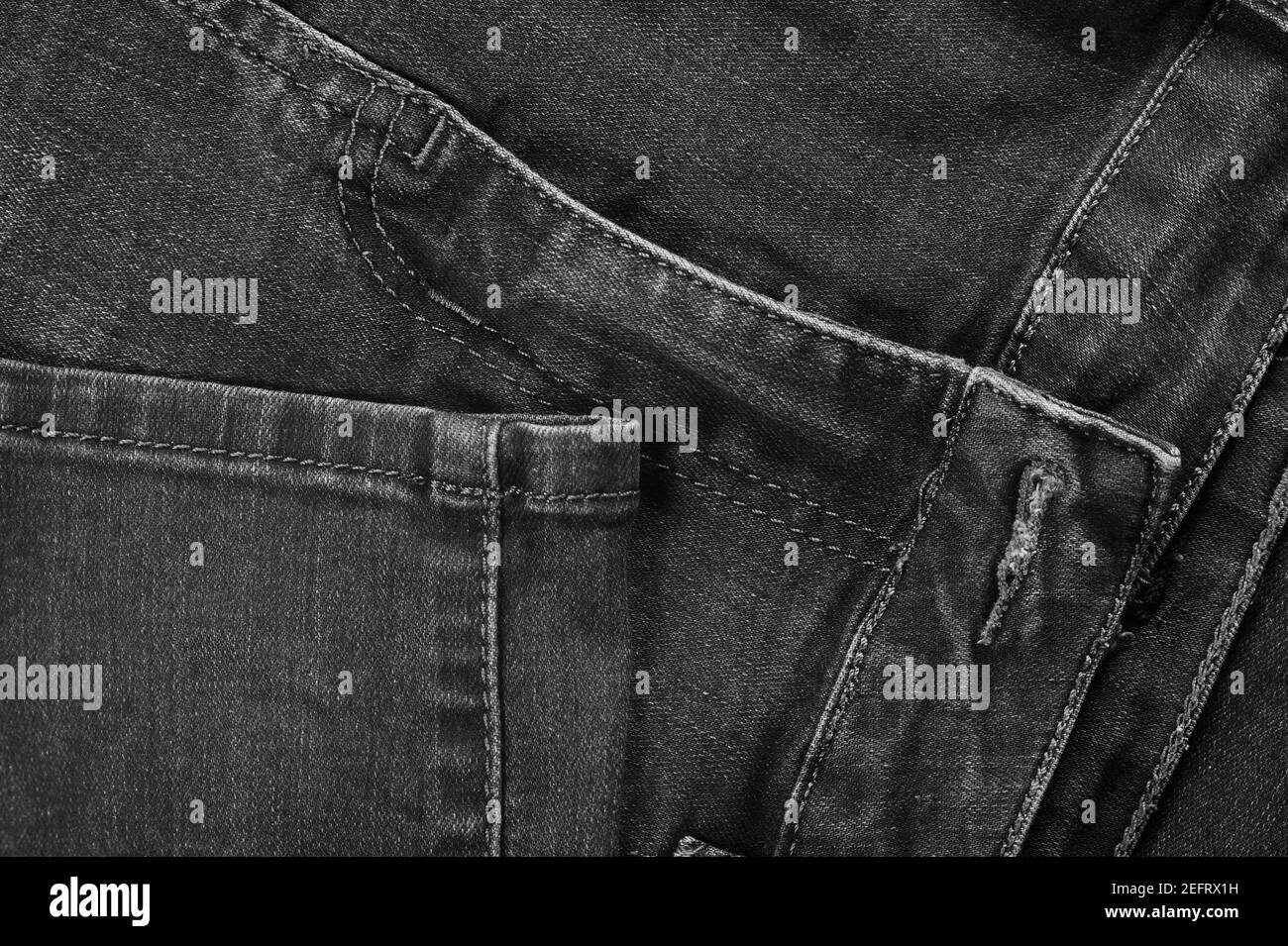 Black jeans fabric (denim). View of the seams of the legs and front of