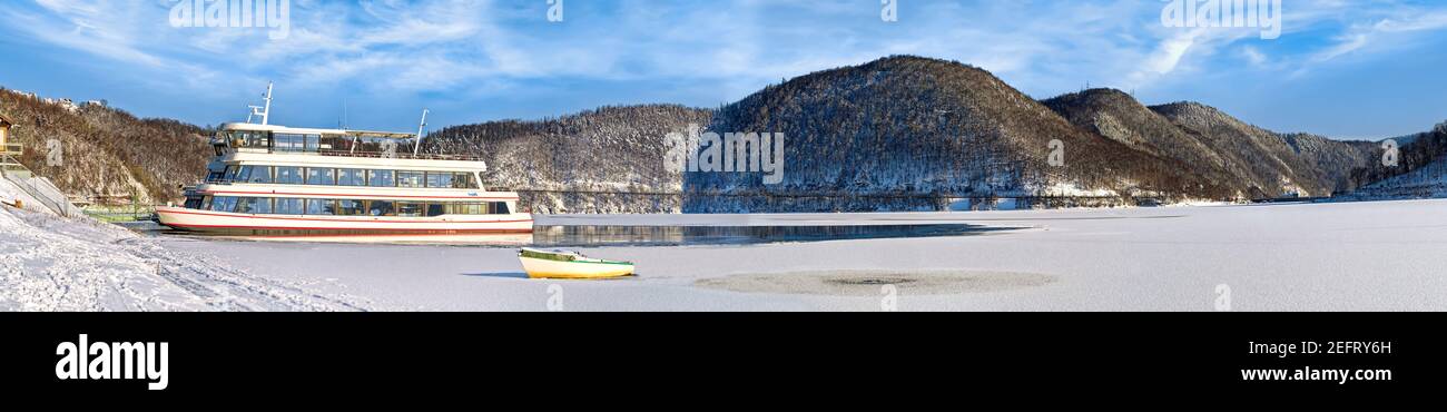 Panorama of the beautiful landscape with snow and excurision ship at the Edersee in winter. Stock Photo
