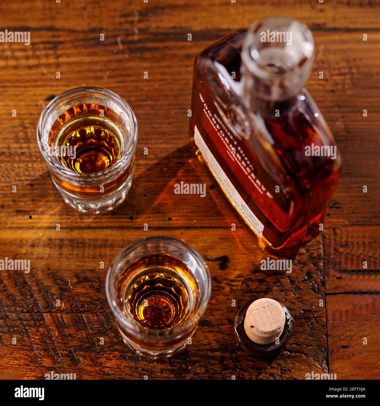 Small bootle of Kentucky Strtaight Bourbon Whiskey with Shot Glasses on a Rustic Wooden Table Stock Photo