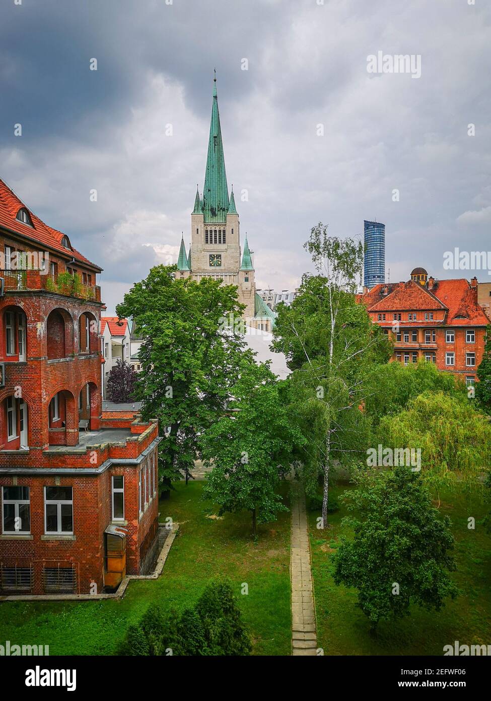 Wroclaw Poland 1 June 2019 Cathedral tower with green roof and Sky tower at cloudy day seen from old abandoned hospital Stock Photo