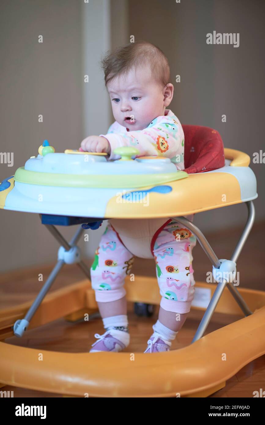 baby learning to walk in walker Stock Photo Alamy