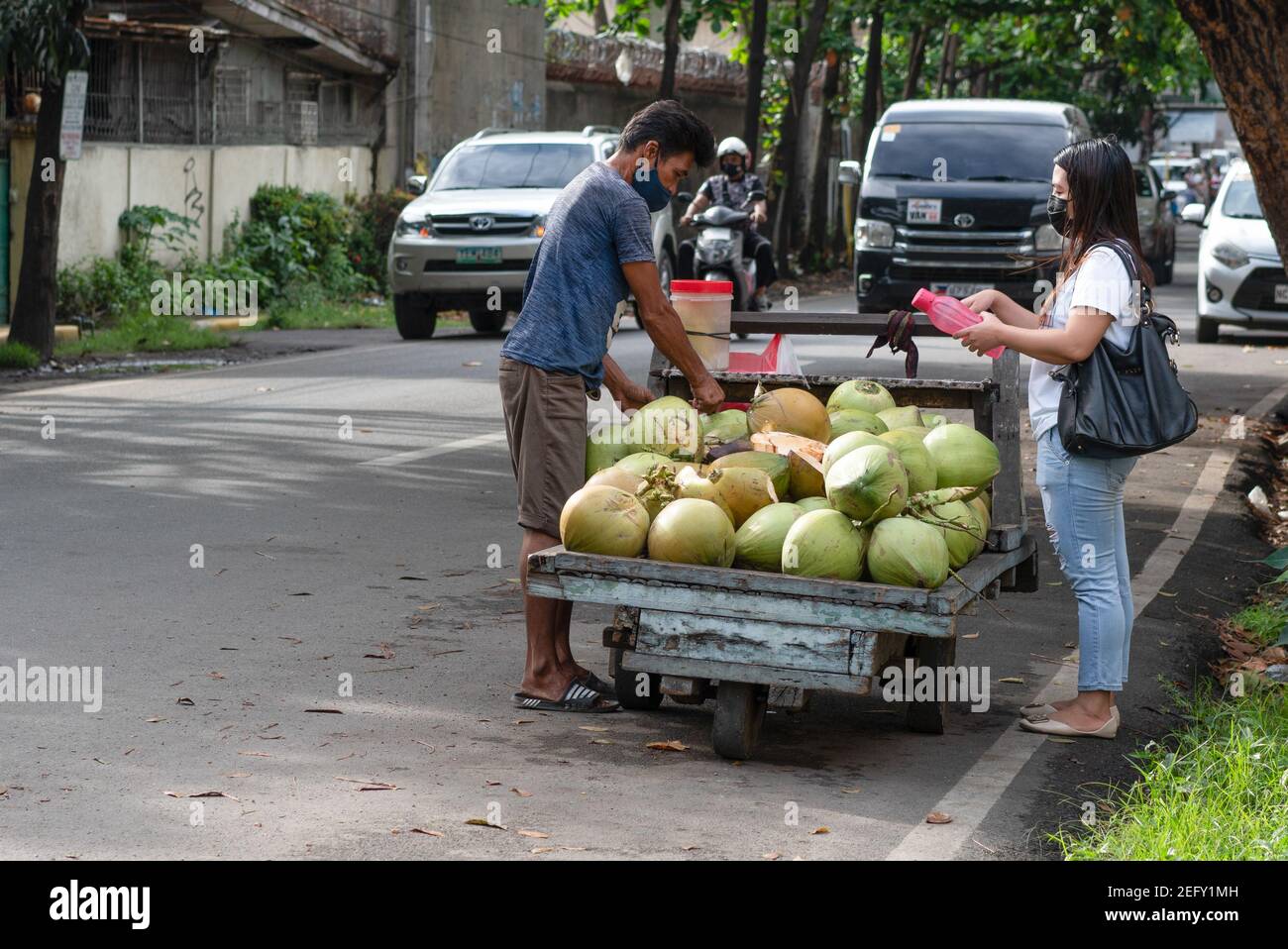 A street coconut vendor selling green coconuts at the roadside, Cebu City, Philippines Stock Photo